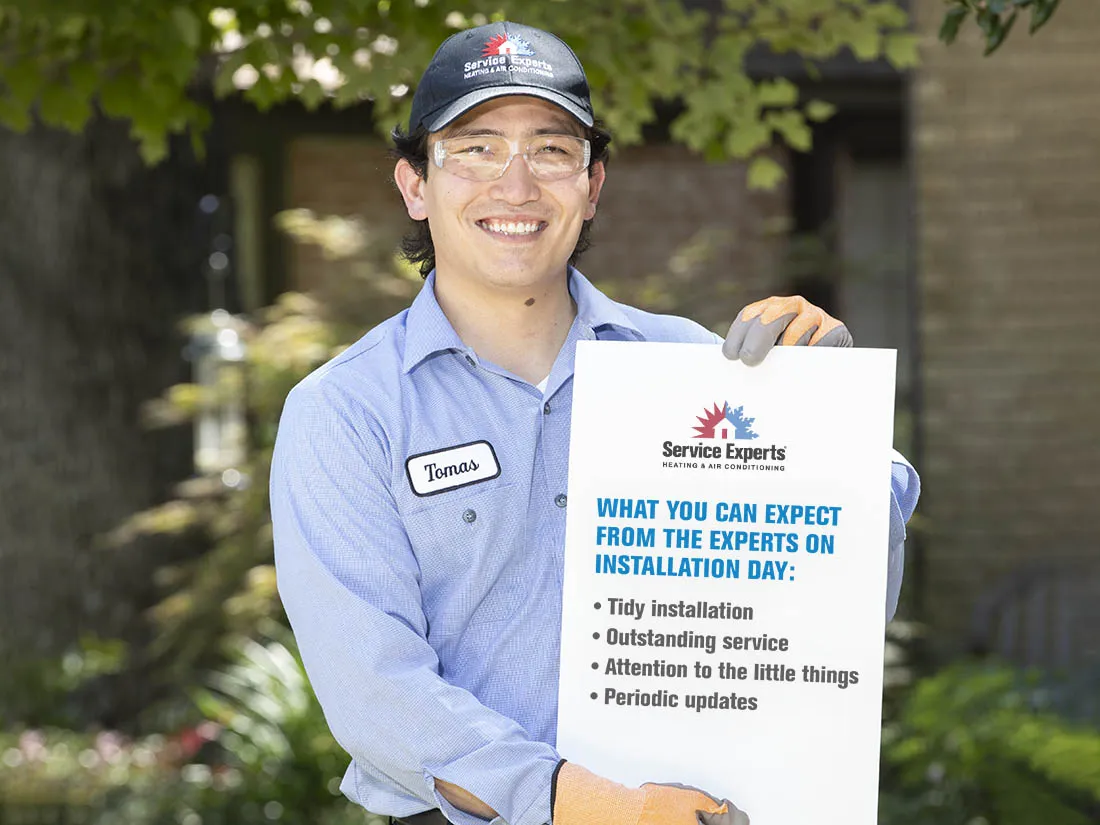 Service Experts technician holding a sign