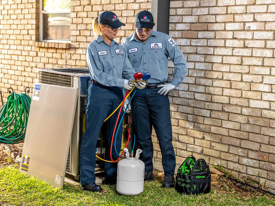 Two Service Experts technicians servicing an air conditioning unit