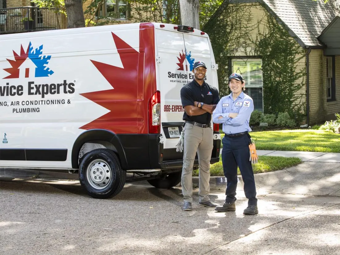 Two Service Experts technicians standing by their van