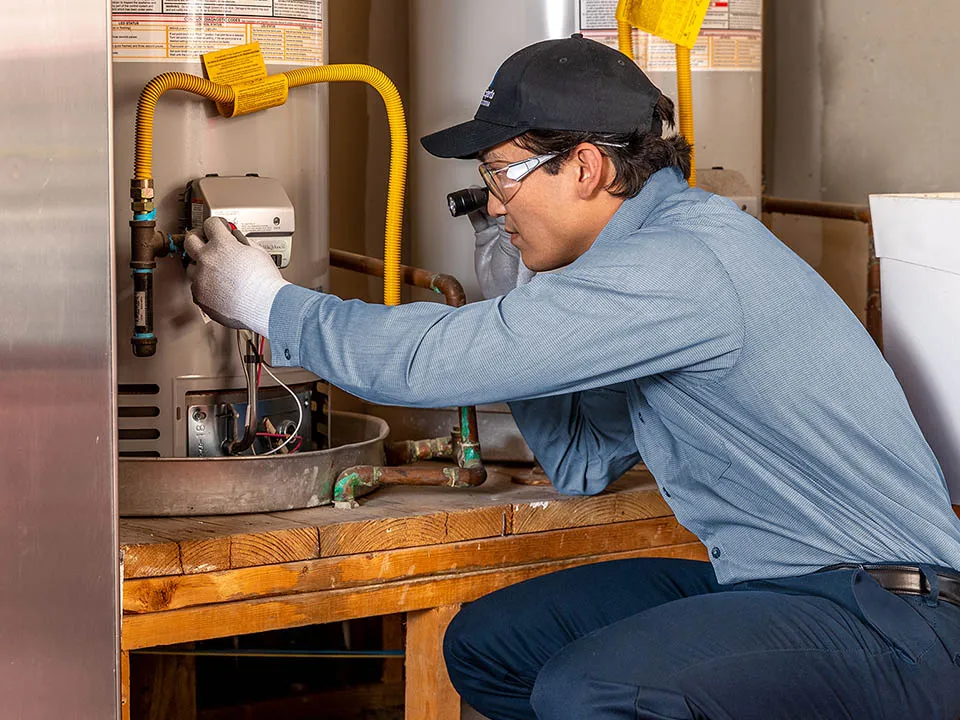 HVAC technician inspecting a water heater