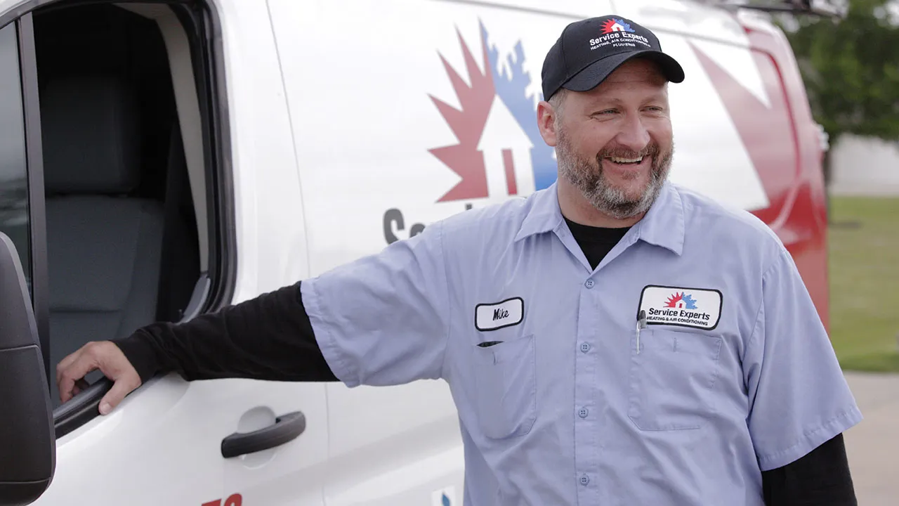 Service Experts technician standing next to vehicle